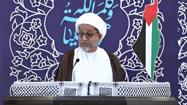 During a Friday sermon at the Imam Al-Sadiq Mosque in Diraz, Sheikh Mohammad Sanqour stands beside the Palestinian flag